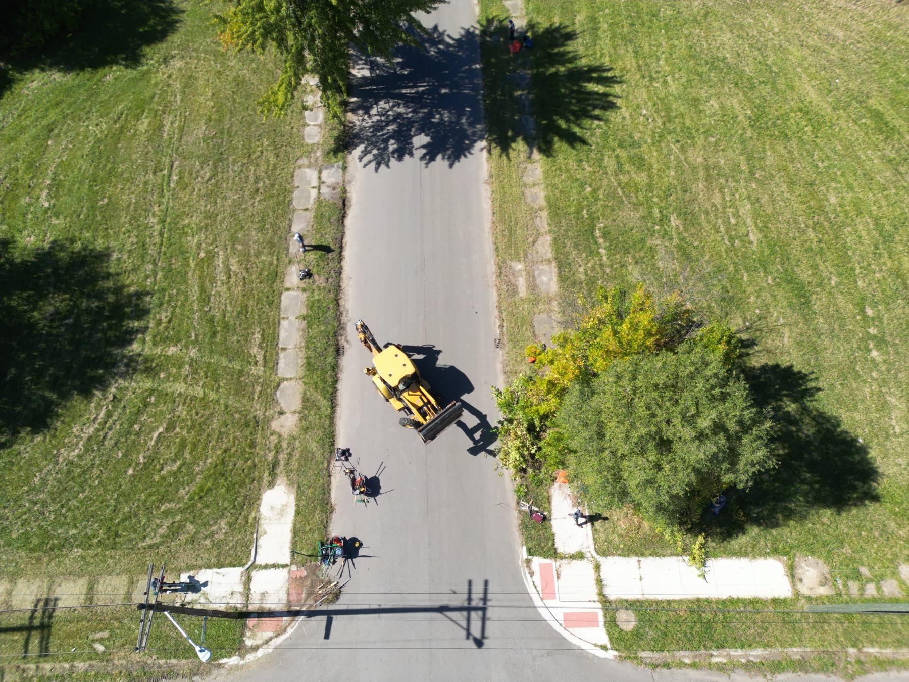 A nadir aerial still of a yellow loader on a residential Detroit street during the Life Remodeled Six Day Project