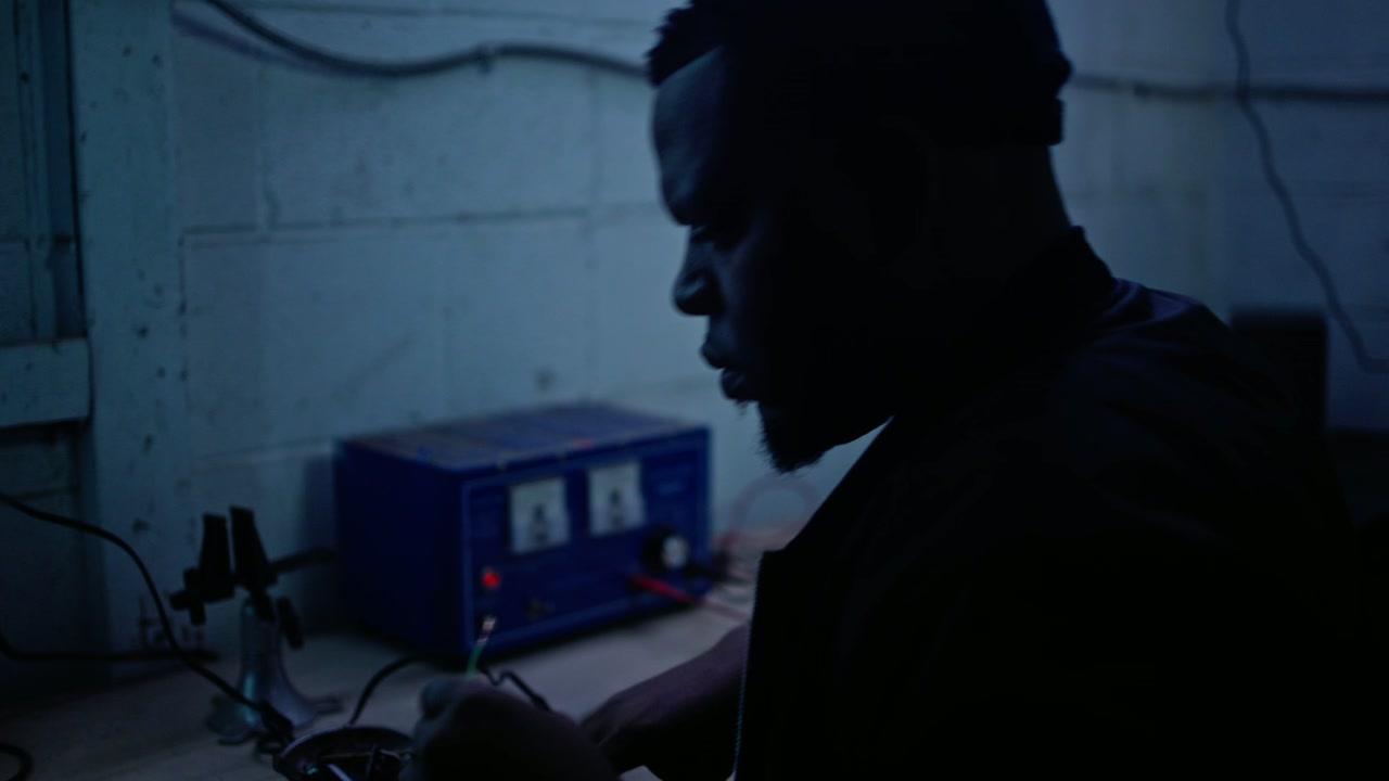 A shadowed inventor at work in Renegade